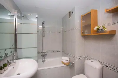 a bathroom with a toilet and a tub and a sink at SingularStays Poeta Querol in Valencia