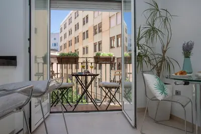 a room with a balcony with a table and chairs at SingularStays Poeta Querol in Valencia