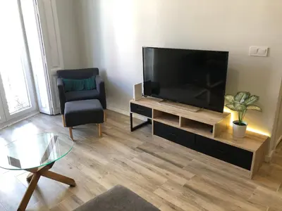 a living room with a flat screen tv and a chair at Botanic in Valencia