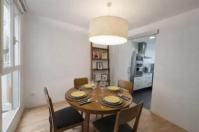 a dining room with a wooden table and chairs at FLORIT FLATS - The Jardines del Turia Apartment in Valencia