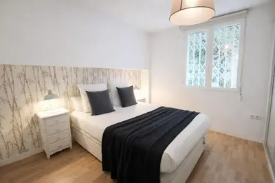 a bedroom with a large white bed and a window at FLORIT FLATS - The Jardines del Turia Apartment in Valencia