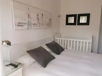 a white bedroom with a white bed with two pillows at Perfecto apto a orillas del mediterráneo / 4PAX in El Perellonet