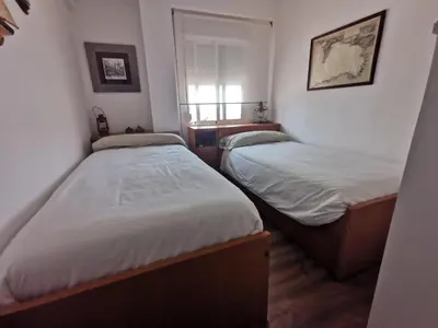 two twin beds in a room with a window at Perfecto apto a orillas del mediterráneo / 4PAX in El Perellonet