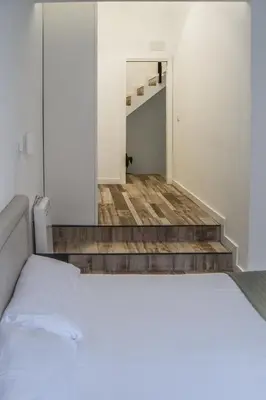 a bedroom with a white bed and a staircase at NWT Central Station Apartments in Valencia