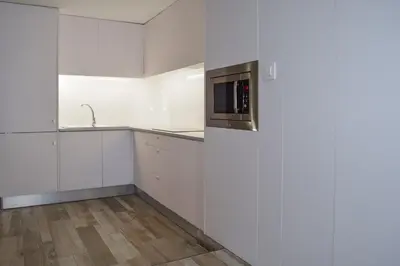 a kitchen with white cabinets and a microwave at NWT Central Station Apartments in Valencia