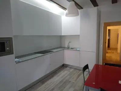 a kitchen with white cabinets and a red table and a red table sidx sidx sidx at NWT Central Station Apartments in Valencia