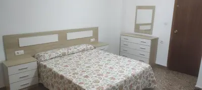 a bedroom with a bed and a dresser and a mirror at playa y relax valencia in Puerto de Sagunto
