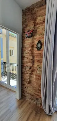 a room with a brick wall next to a door at L'Arbre in Valencia