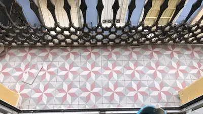 a white and pink tiled wall with a black railing at L'Arbre in Valencia