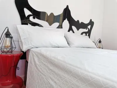 a bedroom with a white bed with a black and white headboard at L'Arbre in Valencia
