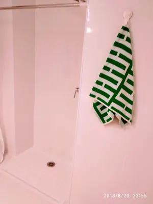 a shower with a green towel hanging on a wall at Valencian Dreams of the Proletariat in Valencia