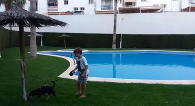 a young boy standing next to a dog near a pool at Habitación doble con baño privado, Desayuno y piscina in Alboraya