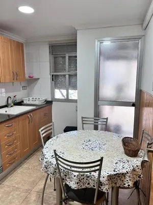 a kitchen with a table with chairs and a table and a table at Plaza Sainetero Arniches in Valencia