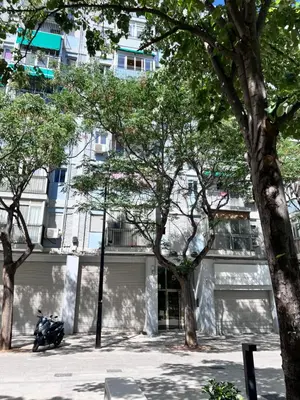 a motorcycle parked in front of a building with trees at Plaza Sainetero Arniches in Valencia