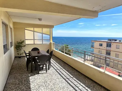 a balcony with a table and chairs and the ocean at Apartamento Careme in Tavernes de Valldigna