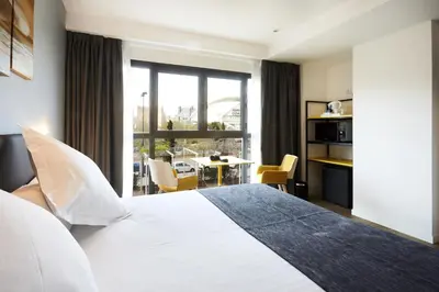a hotel room with a large bed and a table at Sercotel Valencia Alameda 41 in Valencia