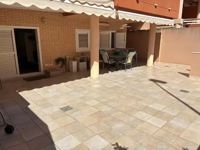 a patio with a table and chairs and a building at Apartamento de lujo en Canet de Berenguer a 150 m de la playa in Canet de Berenguer