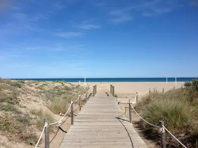 a wooden boardwalk leading to the beach at Apartamento de lujo en Canet de Berenguer a 150 m de la playa in Canet de Berenguer