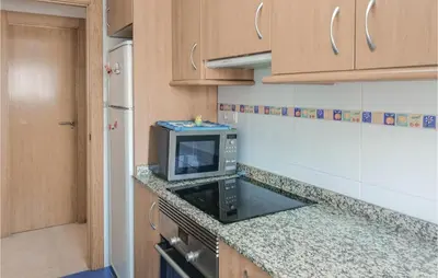 a small kitchen with a microwave on a counter at Cozy Apartment In Moncófar With Wifi in Moncófar