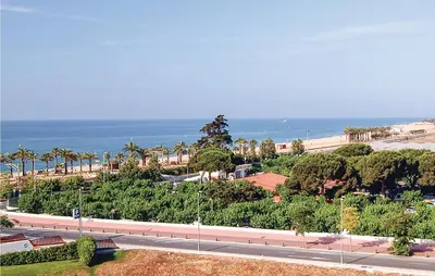 an empty road next to the ocean with palm trees at Cozy Apartment In Moncófar With Wifi in Moncófar