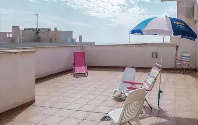 a patio with chairs and an umbrella on a roof at Cozy Apartment In Moncófar With Wifi in Moncófar