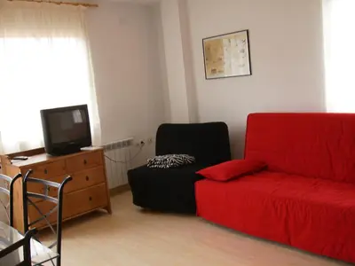 a living room with a red couch and a tv at Apartamentos rurales Benafer in Benafer