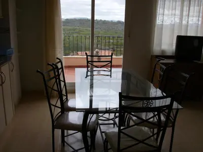 a dining room table and chairs with a view of a balcony at Apartamentos rurales Benafer in Benafer