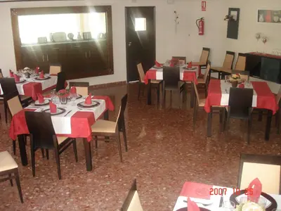 a dining room with tables and chairs with red napkins at Hostal Millán in Segorbe