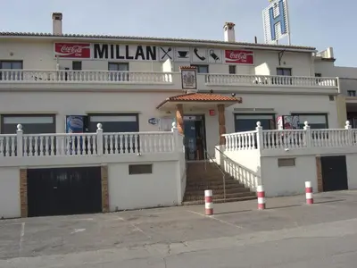 a white building with a staircase leading to the entrance at Hostal Millán in Segorbe