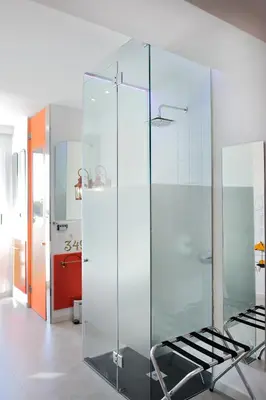 a glass shower in a bathroom with a chair at Hotel Boutique Sabbia Valencia in Valencia