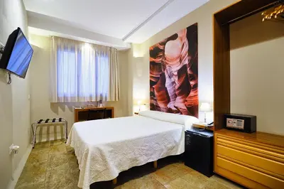 a bedroom with a bed and a tv in it at Hotel Boutique Sabbia Valencia in Valencia