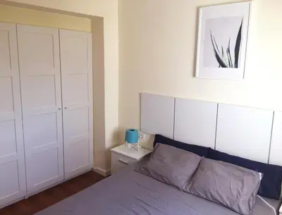 a bedroom with a bed and a white closet at Ático cerca del mar in Valencia