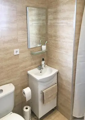 a bathroom with a toilet and a sink and a mirror at Ático cerca del mar in Valencia