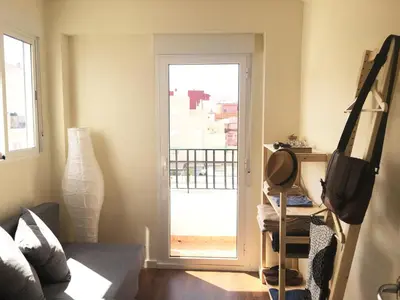 a living room with a door leading to a balcony at Ático cerca del mar in Valencia