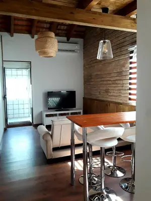 a living room with a table and chairs and a television at Preciosa Casita Cerca Del Mar in Valencia
