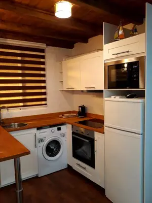 a kitchen with white cabinets and a washing machine at Preciosa Casita Cerca Del Mar in Valencia