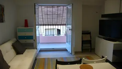 a living room with a white couch and a large window at Apartamento Portalet 7 in Benaguacil