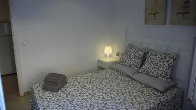 a small bedroom with a bed with a lamp on it at Apartamento Portalet 7 in Benaguacil