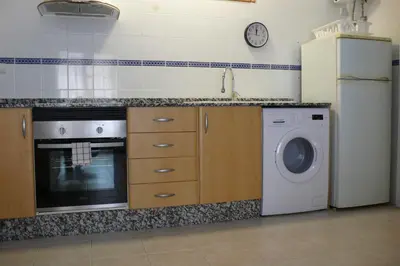 a kitchen with a washing machine and a refrigerator at Apartamento Portalet 7 in Benaguacil