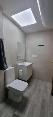 a bathroom with a white toilet and a sink at Apartamento Florazar 2, 8ºC in Cullera