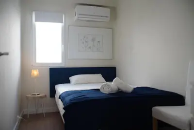 a bedroom with a bed with blue sheets and a window at TTdSSa VLC Plaza Cisneros in Valencia