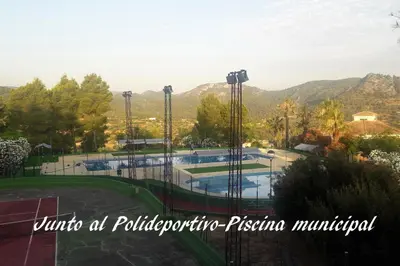 a swimming pool in a park with mountains in the background at Hotel de Montaña La Rocha in Quesa