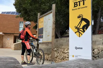 a man standing next to a bike next to a sign at Hotel de Montaña La Rocha in Quesa
