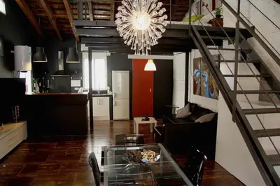 a living room with a glass table and a staircase at Penthouse in historic center in Valencia