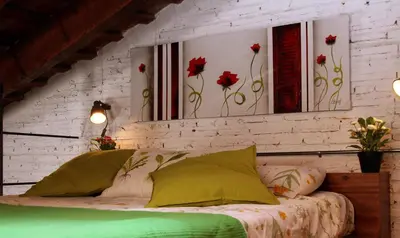 a bedroom with a bed with red flowers on the wall at Penthouse in historic center in Valencia