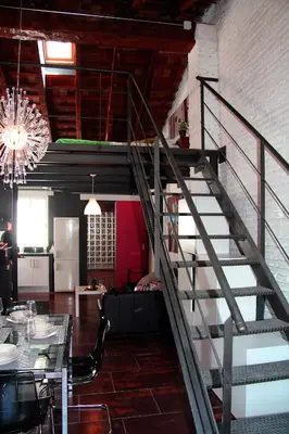 a staircase in a room with a table and a dining room at Penthouse in historic center in Valencia