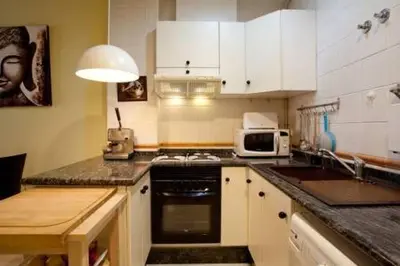 a kitchen with white cabinets and a stove top oven at Apartament in historic center in Valencia