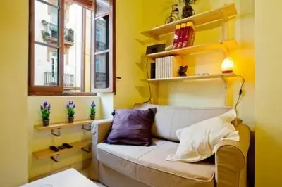 a yellow living room with a couch and a window at Apartament in historic center in Valencia