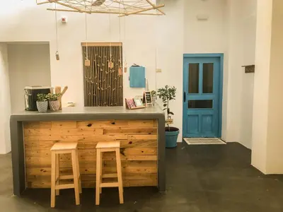 a kitchen with two stools and a counter with a blue door at Cantagua Hostel in Valencia