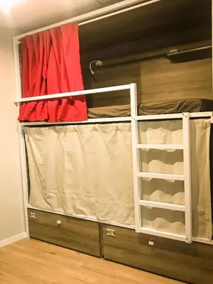 a closet with a bed and a red curtain at Cantagua Hostel in Valencia